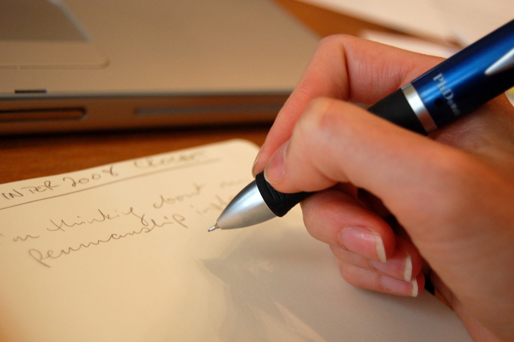 woman's hand writing with pen